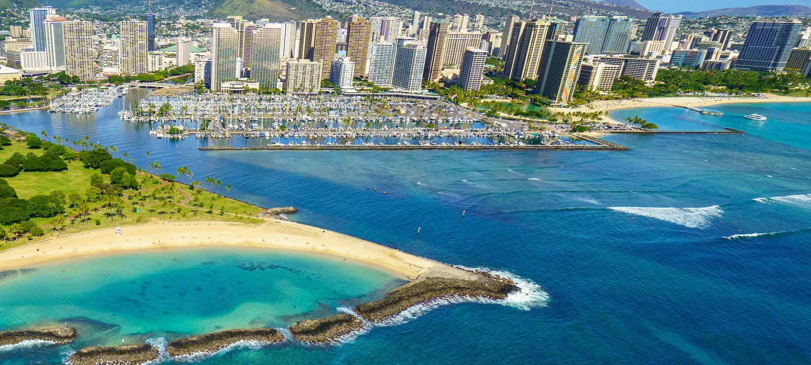 Aerial view of the Ala Wai Harbor, Magic Island and the Honolulu skyline with turquoise reef water, Oahu, Hawaii