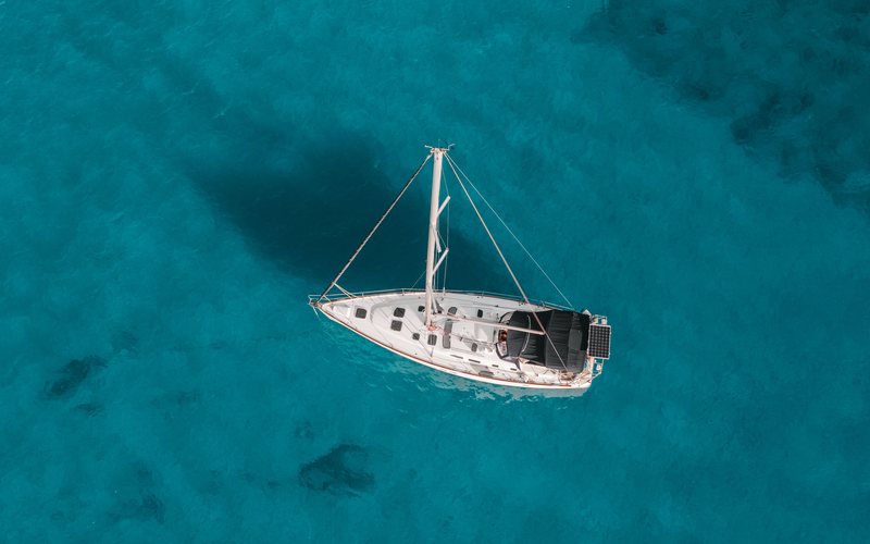 Aerial view of a boat anchored over clear turquoise water off Oahu, Hawaii