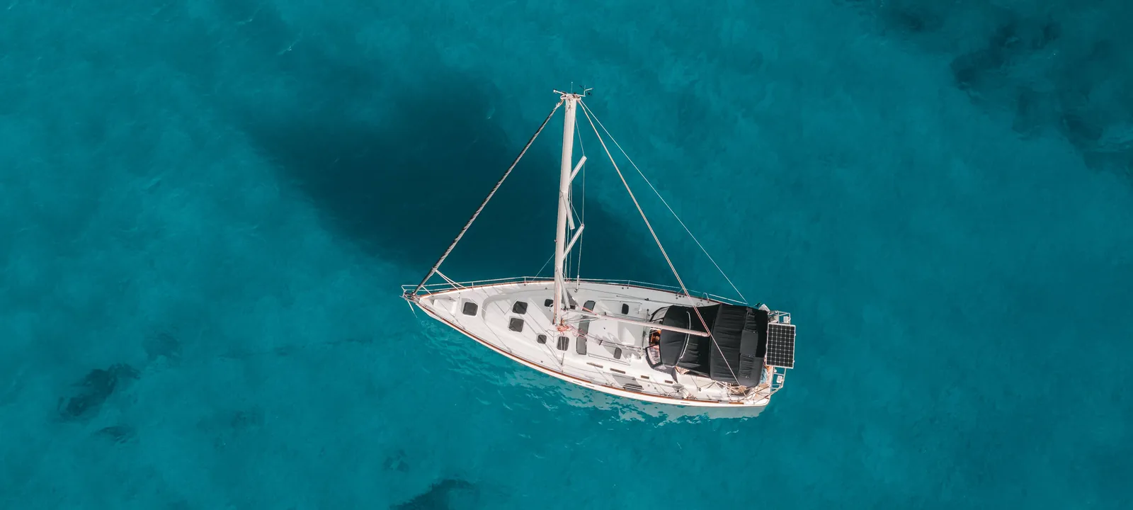 Aerial view of a boat anchored over clear turquoise water off Oahu, Hawaii