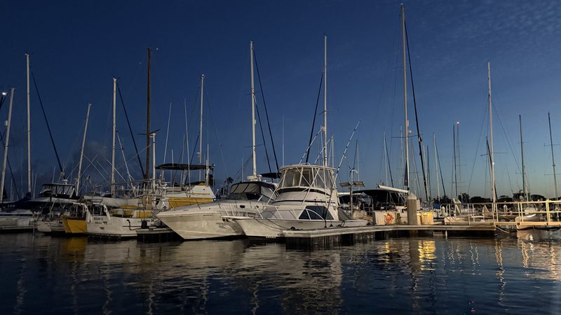 Boats moored at the Ala Wai Boat Harbor at dusk with a Honolulu transom, Oahu, Hawaii