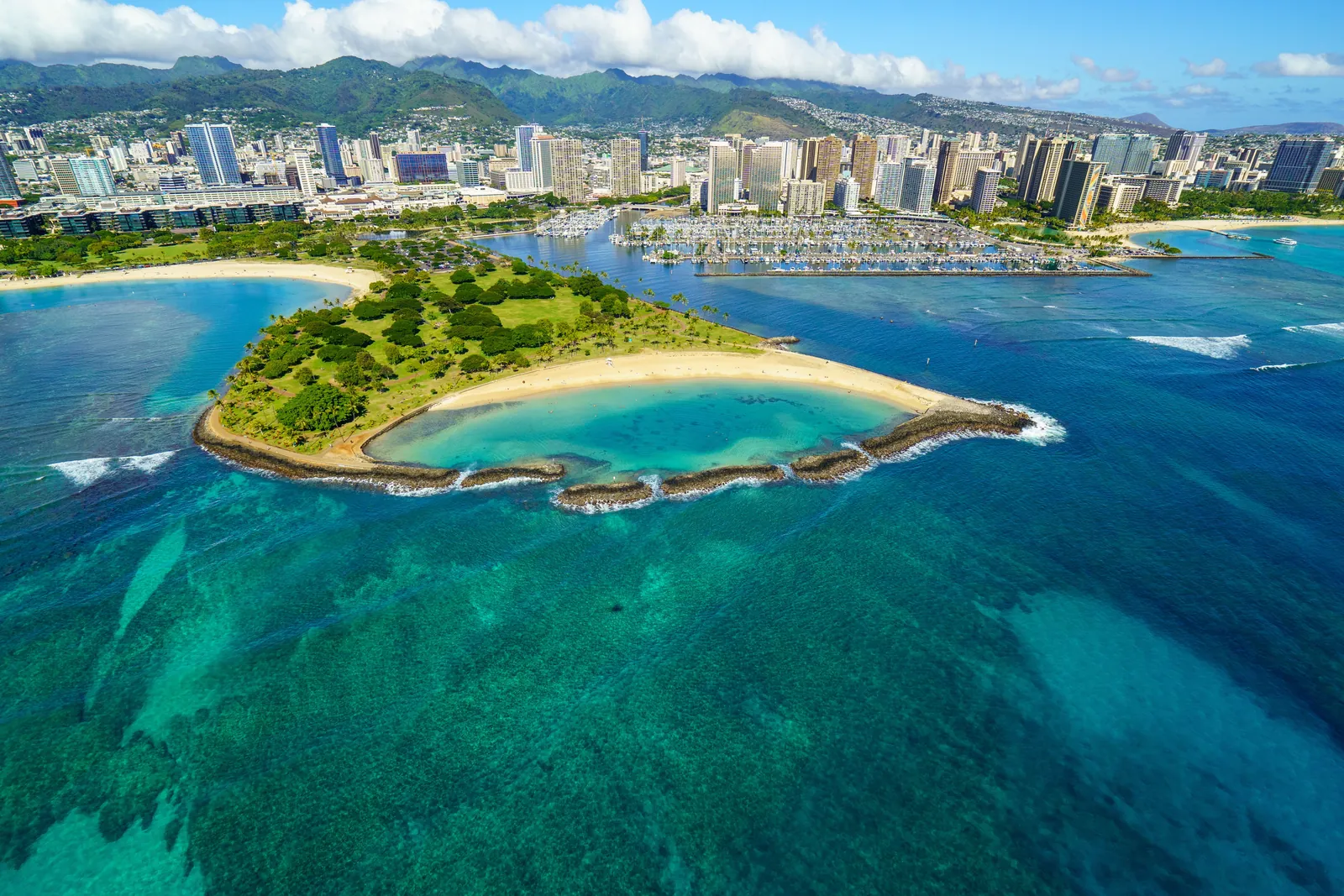 Aerial view of Ala Wai Harbor full of boats, Magic Island, and the Honolulu skyline on Oahu